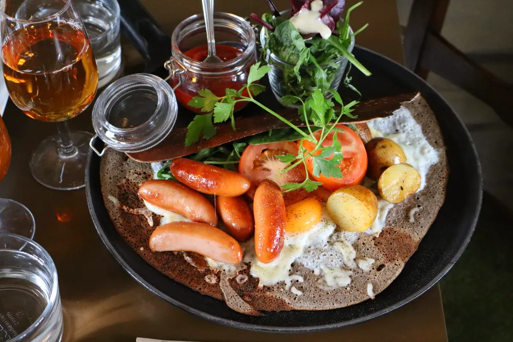brunch skåne på byn creperie SUEDOISE Prinskorv, stekt potatis, ägg, riven ost, tomat, chilisås